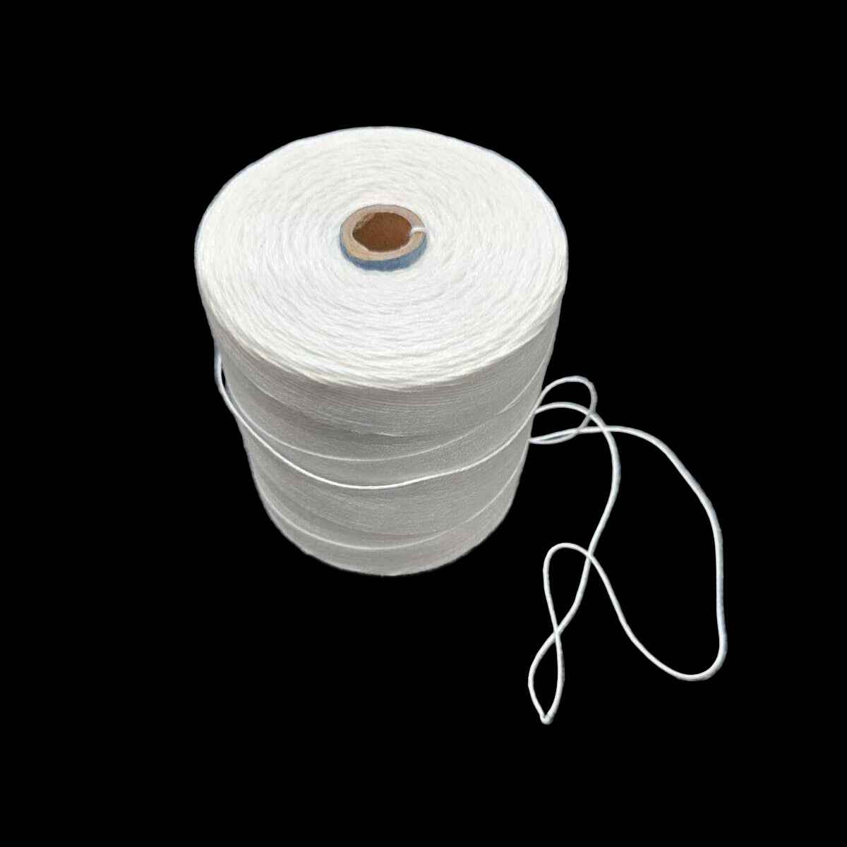 Spool of white thread on a textured gray surface