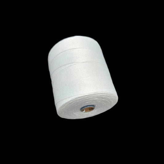 White reel of string on a textured gray surface